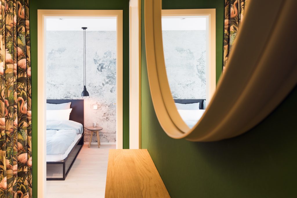 Stadtwohnung, Spiegel aus Holz, grüne Wand, Bett